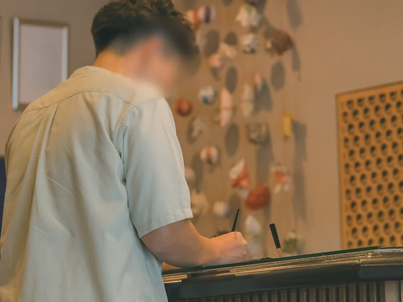 旅館へチェックインする男性