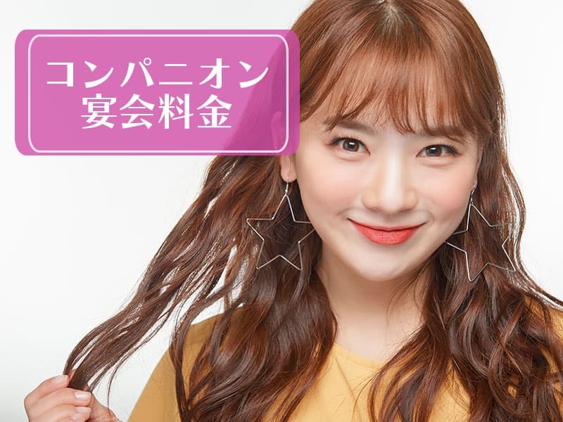 長いパーマのかかった髪を笑顔でいる女性