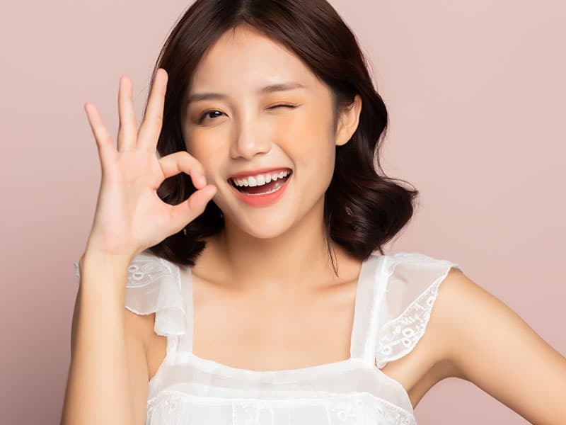 OKマークをつくる可愛い白い衣装の20代女性