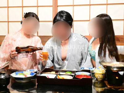 コンパニオンにお酒をついでもらう男性